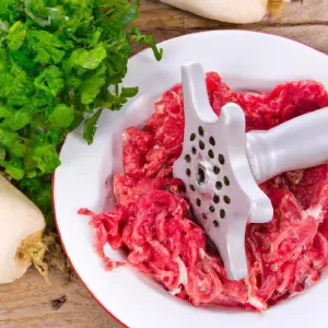 Soczysty stek ribeye na drewnianej desce, przyprawiony świeżym rozmarynem, pieprzem i solą morską.